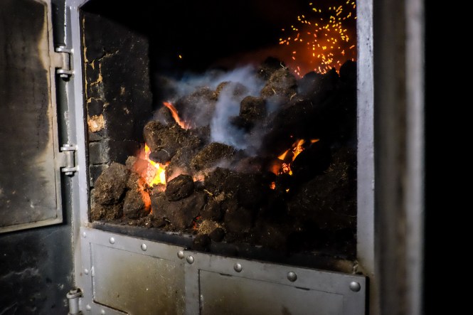 Outdoor copper bathtub with a view of Lochnagar Mountain at sunset, showcasing the alpenglow and the luxury experience.