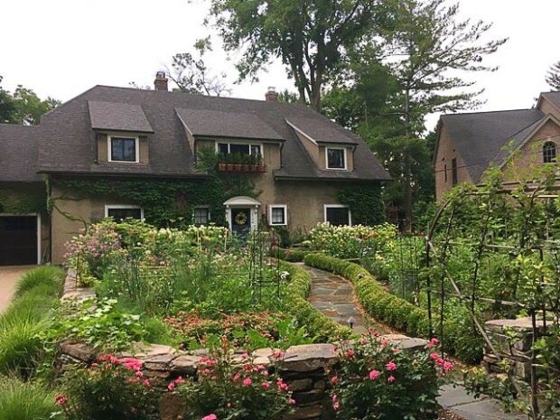a dry stacked stone wall alongside a garden