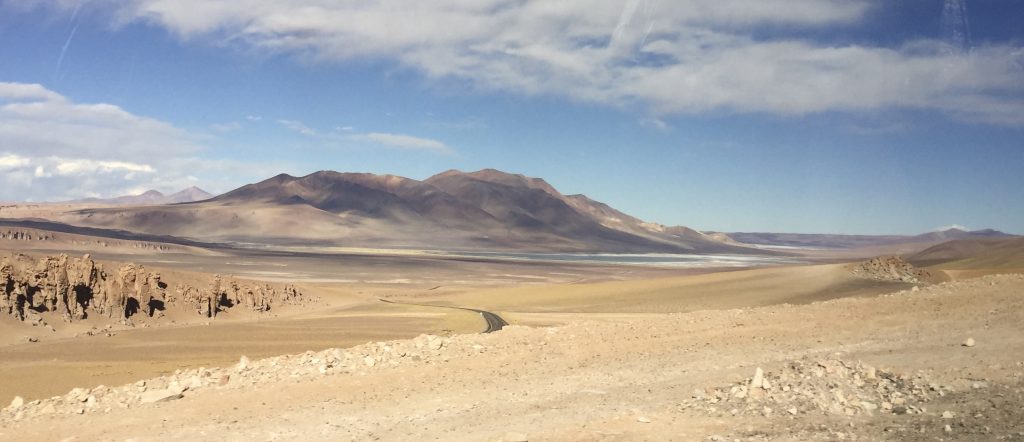 A close-up shot of the cracked, arid earth in the Atacama Desert, highlighting the stark, unforgiving landscape and geological textures.