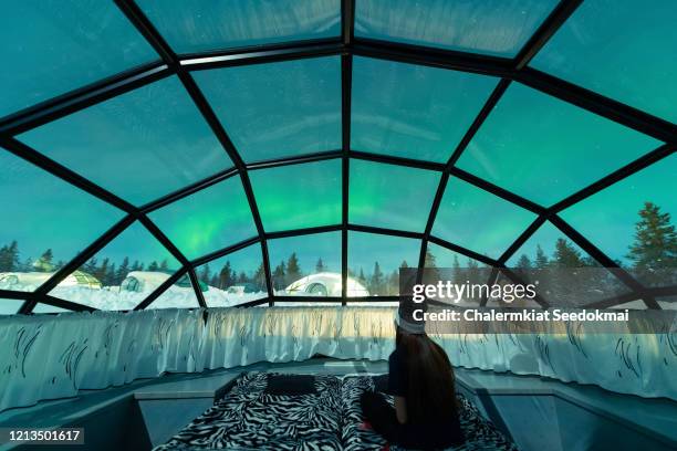 The starry sky above Kakslauttanen Arctic Resort, with constellations and faint aurora streaks visible. The glass igloos glow softly below.