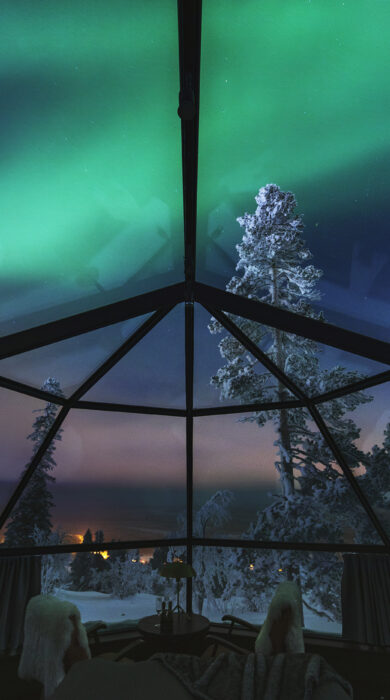 Low-angle shot of the icebreaker plowing through the ice, emphasizing its size and power.