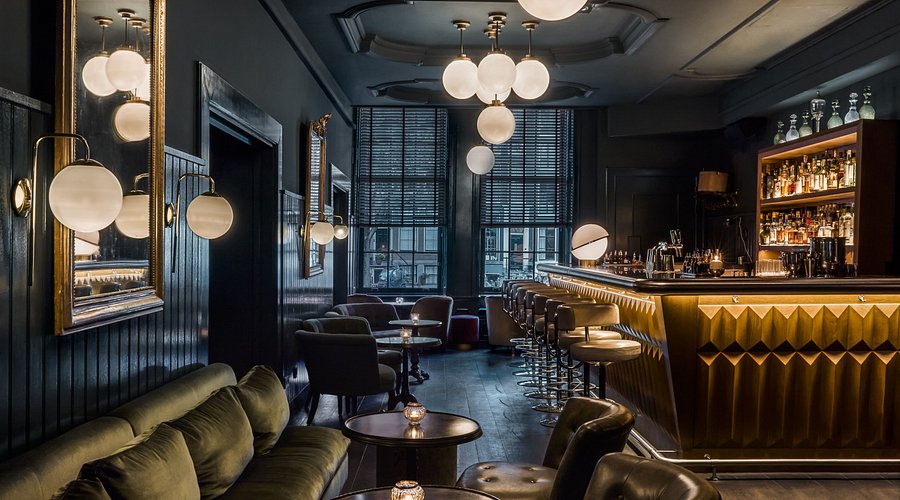 Interior of a luxurious suite at The Pulitzer Amsterdam, showcasing a canal view through leaded windows and elegant decor