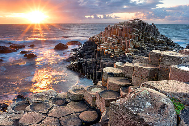 Hexagonal basalt columns at the Giant's Causeway, Northern Ireland, during sunset, showcasing the unique patterns and textures formed by the cooling lava.