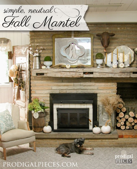 A simple and neutral fall mantel arrangement with pumpkins, white candles, and natural elements