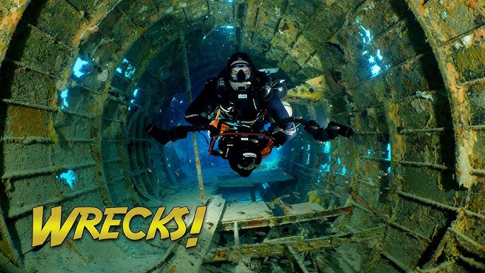 An underwater photograph captures a diver exploring a well-preserved WWII wreck in Truk Lagoon. The image shows both the historical structure and the marine life that has made it home.