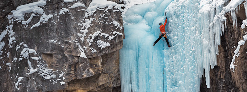 A close-up photo of a picnic spread, highlighting the colors and textures of the food with Lake Louise in the background.