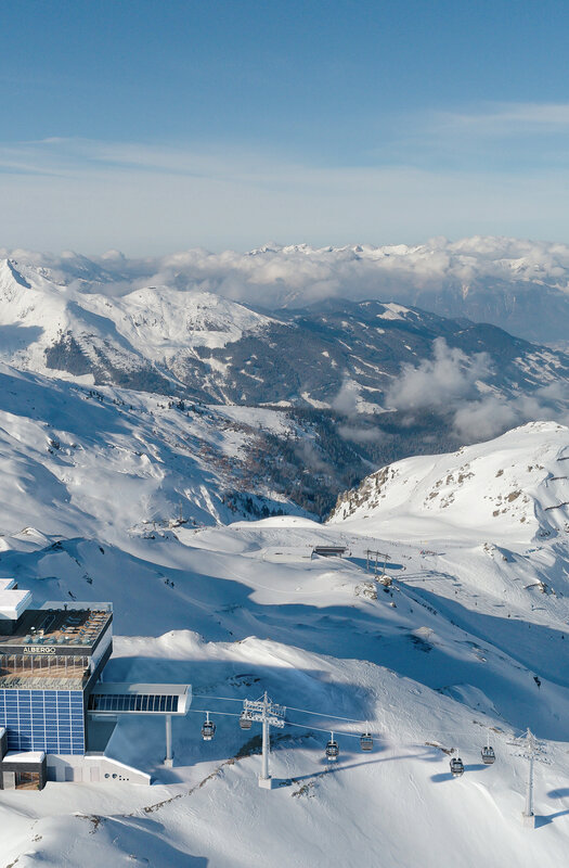A climber clipped into a via ferrata cable with a panoramic alpine view