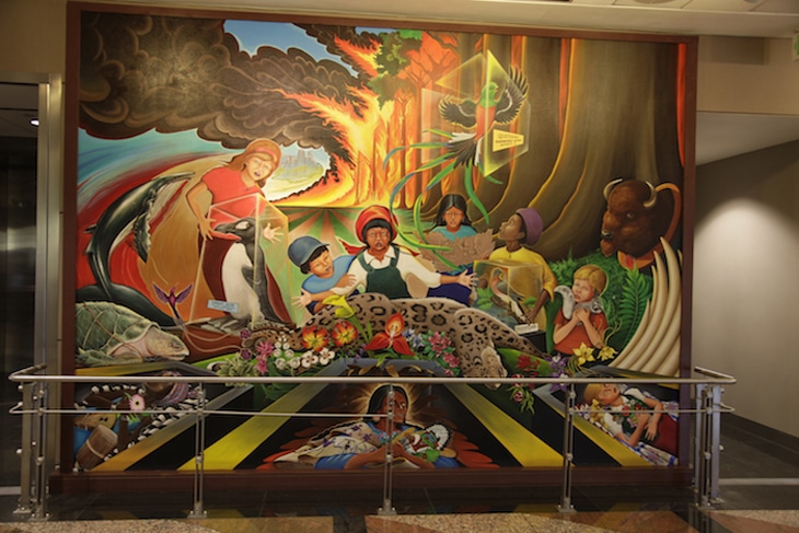 A close-up shot of the sleeping child surrounded by animals in Leo Tanguma's 