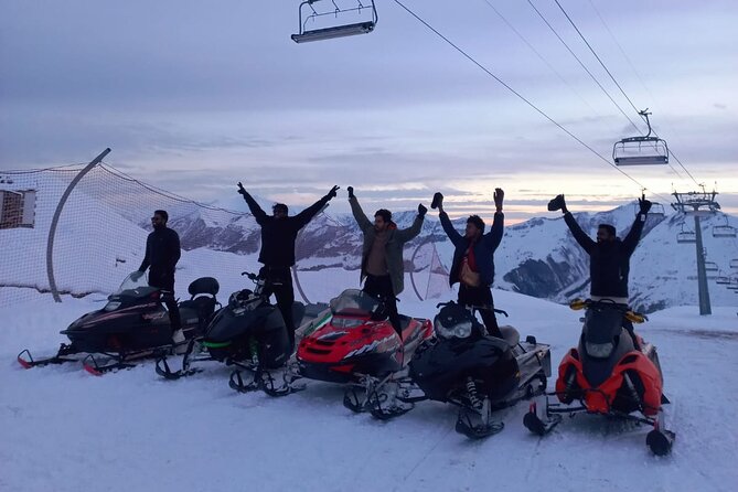 A wide shot of the mountains, with tiny figures of kayakers carving through the snow.