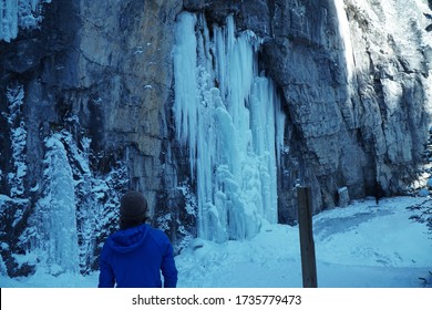 Climber ascending a frozen waterfall in Grotto Canyon