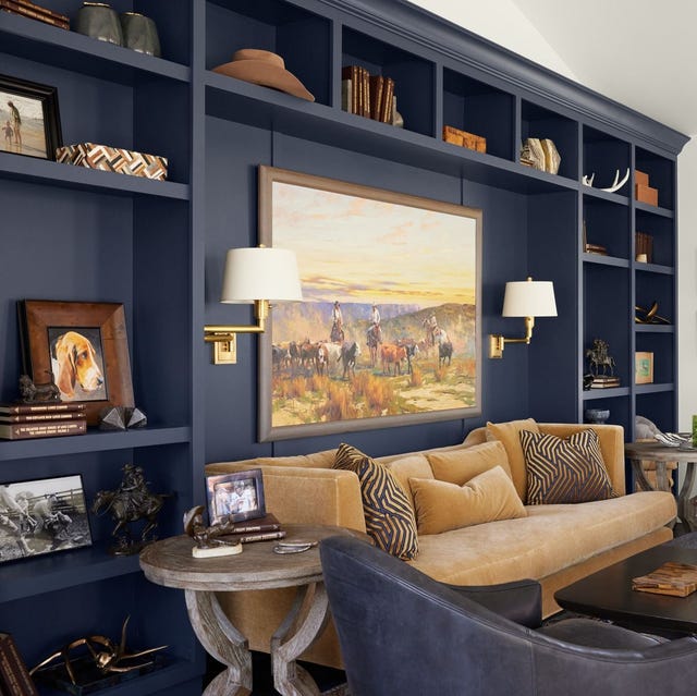 A partially visible, comfortable armchair draped with a chunky knit cream-colored blanket, inviting relaxation.