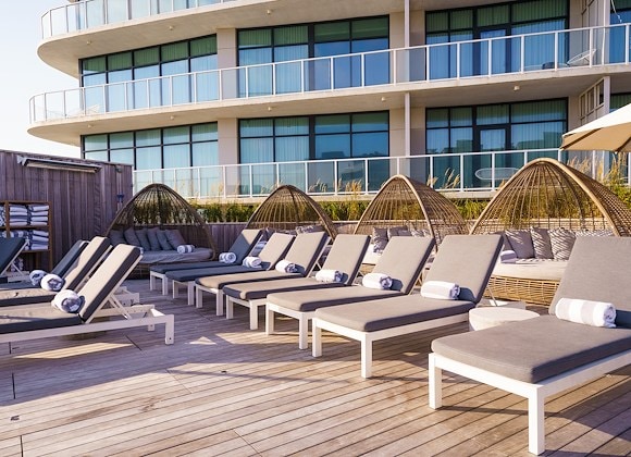 The rooftop terrace at Le Secret Marais, showcasing panoramic views of the Paris skyline at sunset.