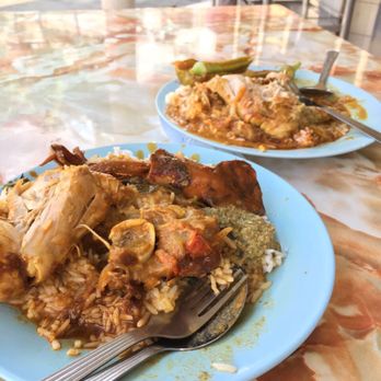 A close-up shot of the various curries being ladled onto the rice at Line Clear Nasi Kandar, highlighting the vibrant colors and textures.