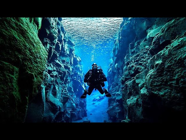 Surreal, alien clarity of Silfra Fissure with a diver suspended in the turquoise water