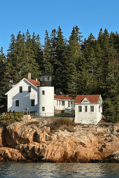 A stack of blueberry pancakes topped with butter and a side of maple syrup.