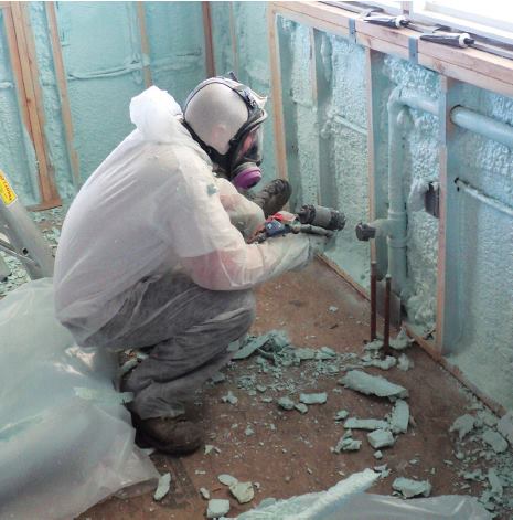 A hand caulking around a window frame, demonstrating how to seal air leaks.