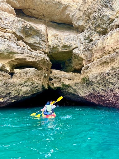 Praia de Benagil: Explore Algarve's sea caves by boat or kayak for stunning views of light and shadow, emphasizing natural beauty.