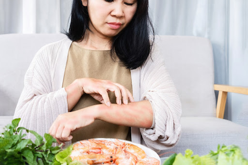 A close-up photograph of a hand applying walnut oil to a wooden cutting board. The image should focus on the texture of the wood and the oil being absorbed. The lighting should be warm and diffused, creating a soft, inviting mood.