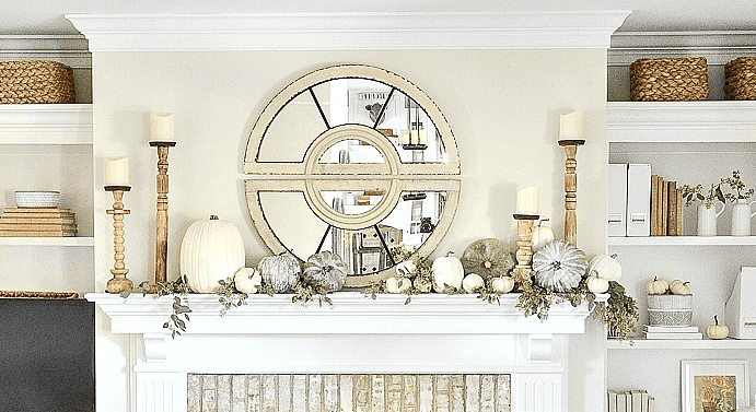 A farmhouse mantel decorated for fall with white pumpkins and other natural elements