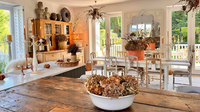 A close-up of a fall-themed table setting, showcasing natural elements like pinecones, leaves, and berries, creating a rustic and inviting atmosphere.