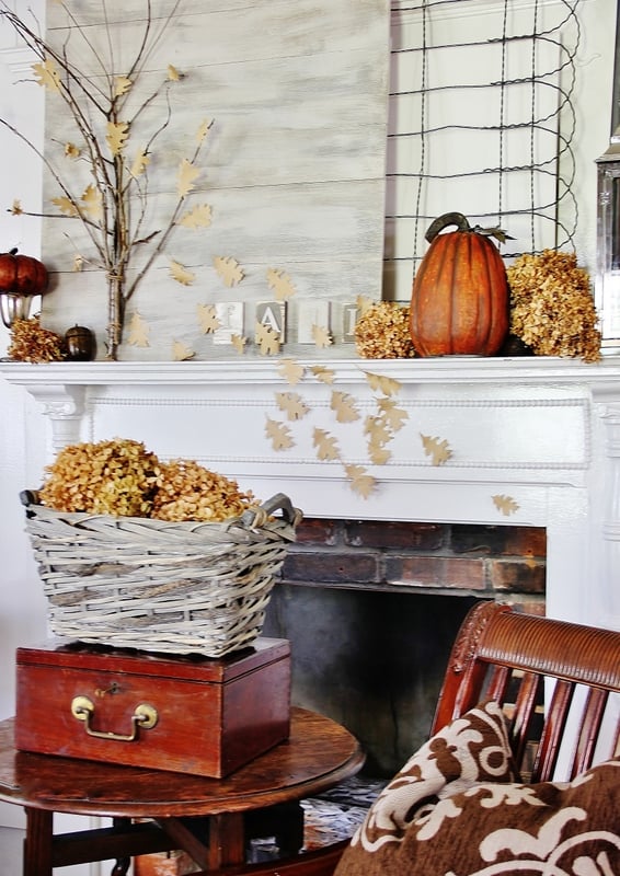 Close-up of dried hydrangeas and pinecones used as mantel decor, highlighting natural textures