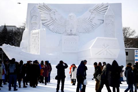 A large, intricately carved snow sculpture depicting Ainu folklore at the Sapporo Snow Festival, showing the artistry and cultural significance of the event.