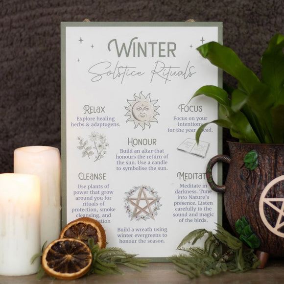 A collection of repurposed vintage glass jars and bottles displayed on open shelving, filled with bath salts, cotton swabs, and homemade lotions in a rustic winter solstice bathroom.