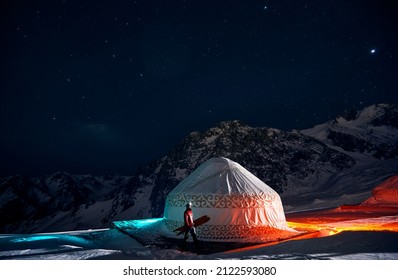 A traditional Mongolian yurt (ger) set against the vast, undulating sand dunes of the Gobi Desert under a clear blue sky.