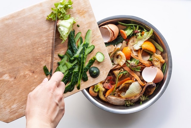 Compost tumbler full food scraps garden tools