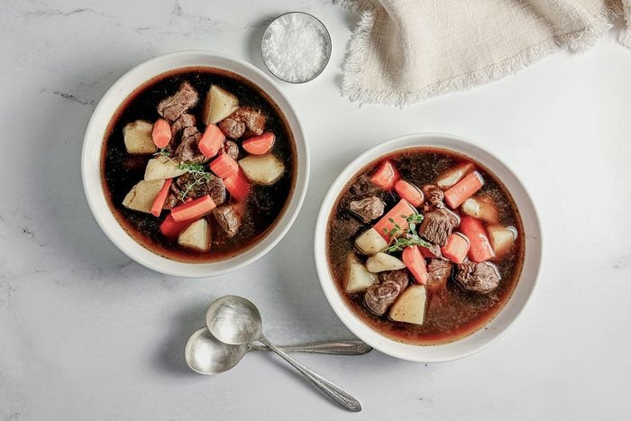 Preparing venison stew meat by trimming excess fat and seasoning, highlighting the initial step for a flavorful and tender stew.