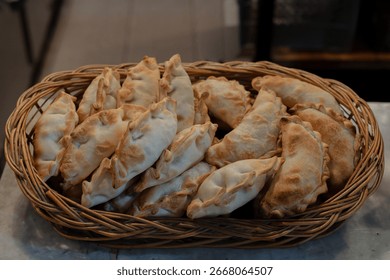 A collage of four empanadas (Carne, Pollo, Humita, Espinaca) showcasing their distinct fillings and colors within the bustling San Telmo Market.