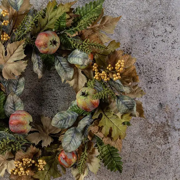 A rustic container filled with branches of vibrant autumn foliage, creating a stunning and colorful entryway display