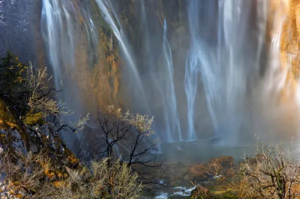 The majestic Veliki Slap waterfall cascading down a rocky cliff, captured with a long exposure to blur the water's movement.