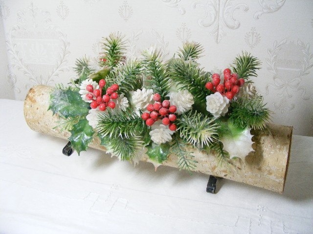 Pinecones, cinnamon sticks and dried orange slices laid out on a rustic wooden surface, ready to be used for crafting a natural Yule Log centerpiece.