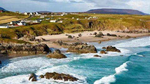 Rugged coastline near Durness, Scotland, with dark blue water and misty atmosphere, where complex seabed topography creates unusual wave sounds, offering a distinct sensory experience.