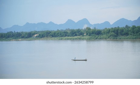 Monks collecting alms during the Tak Bat ceremony at dawn, captured in low light with a wide aperture.