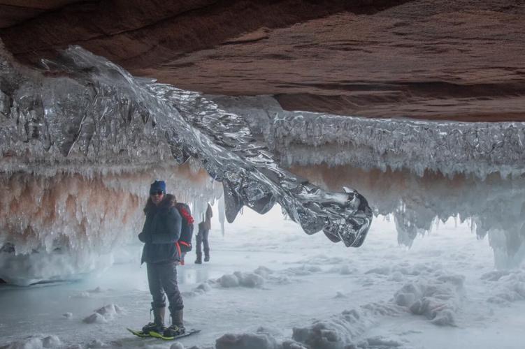 Images of stunning ice formations inside the caves, showcasing the unique beauty of the winter caving experience. Photos of cavers exploring narrow passages with headlamps.