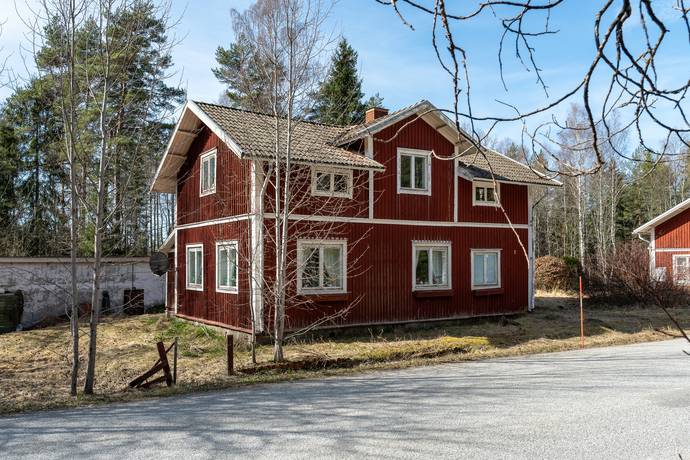 A modern farmhouse-style home with a metal roof and wraparound porch.