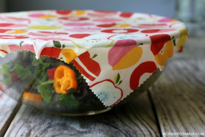 Hand peeling a finished beeswax wrap off of the parchment paper to cool.