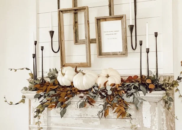 Pinecones neatly displayed inside of a rustic basket, placed next to a fireplace with fall decorations.
