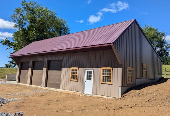 The exterior of a barn, showcasing new siding that matches the rustic charm.