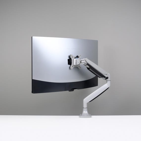 Photo of the PG27AQDM mounted on an Ergotron HX monitor arm, illustrating its compatibility and adjustability.