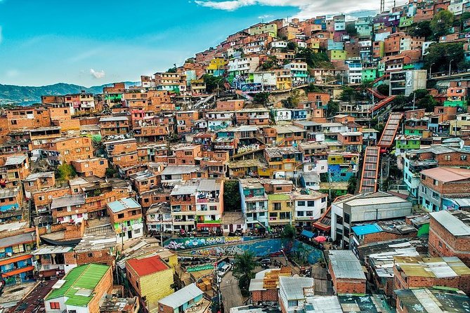 A breathtaking view of Medellin from a paragliding perspective, showcasing the city nestled in the Aburrá Valley with mountains in the background and the Metrocable system visible.