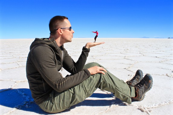Endless white salt flats stretching to the horizon under a clear blue sky