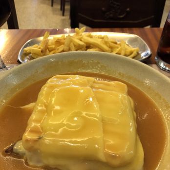 Crowds of tourists taking photos outside a grand bookstore with gothic architecture.