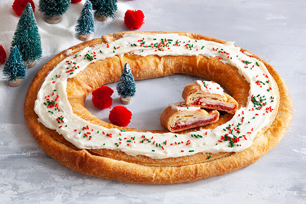 A digitally enhanced overhead photo of incorporating rum-soaked sultanas, candied orange peel, candied lemon peel, almonds, and walnuts into the stollen dough, ensuring even distribution.