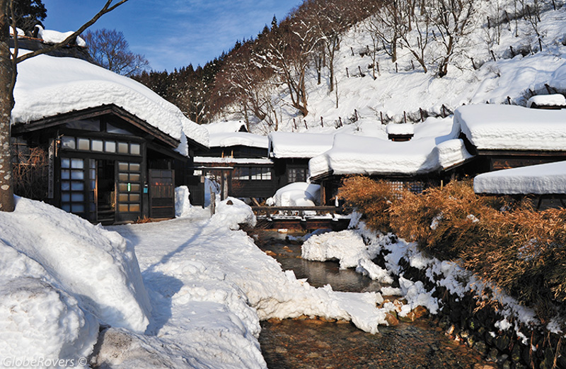 A stunning winter landscape featuring snow-covered evergreens and frozen Lake Akan, illustrating the beauty of snowshoeing in Akan-Mashu National Park.