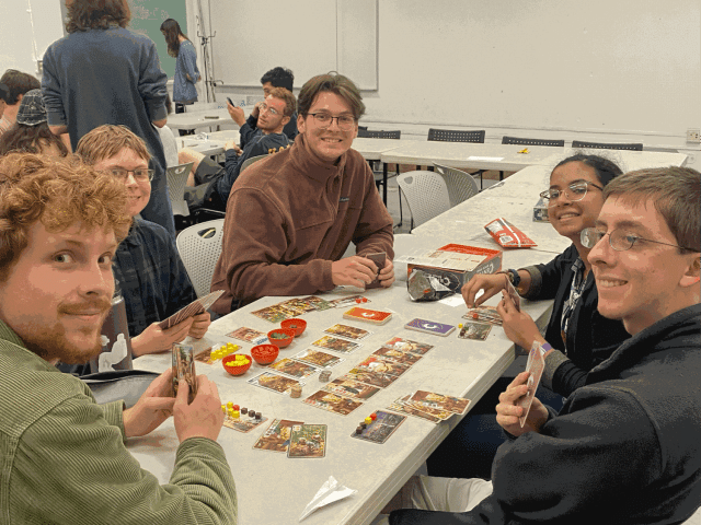 A Twitch stream interface with a streamer playing a board game.