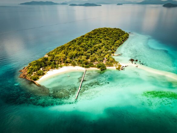 Serene beach on Koh Mak, Thailand with clear water and greenery