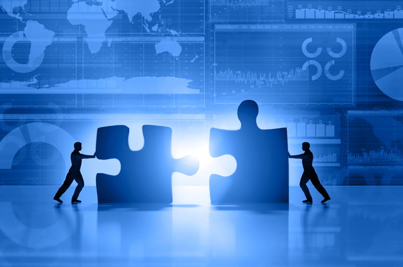 A black and white photo showing a blurred crowd of people protesting in front of a building. The image conveys a sense of social unrest and opposition to corporate decisions.